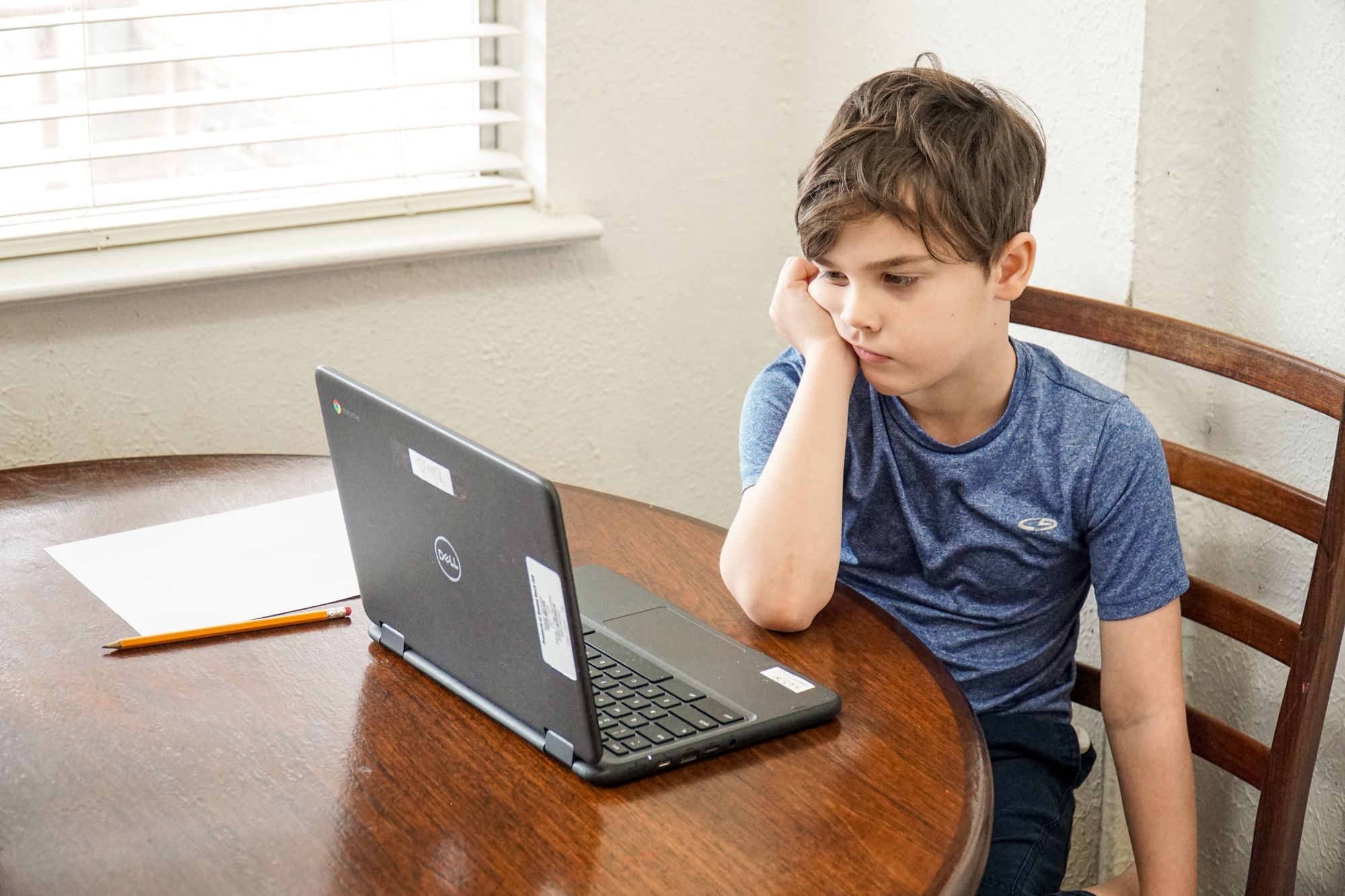 smutny chłopiec patrzący w ekran komputera